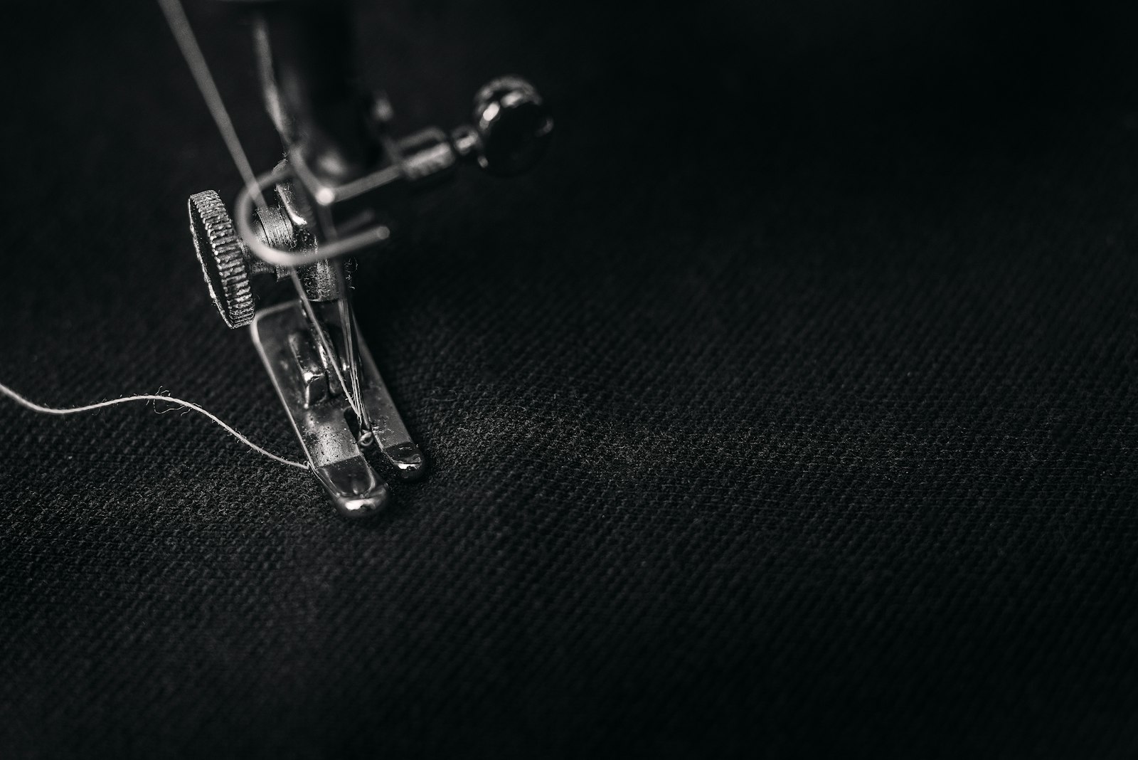 Machine à coudre piquant l'ourlet d'un jean denim